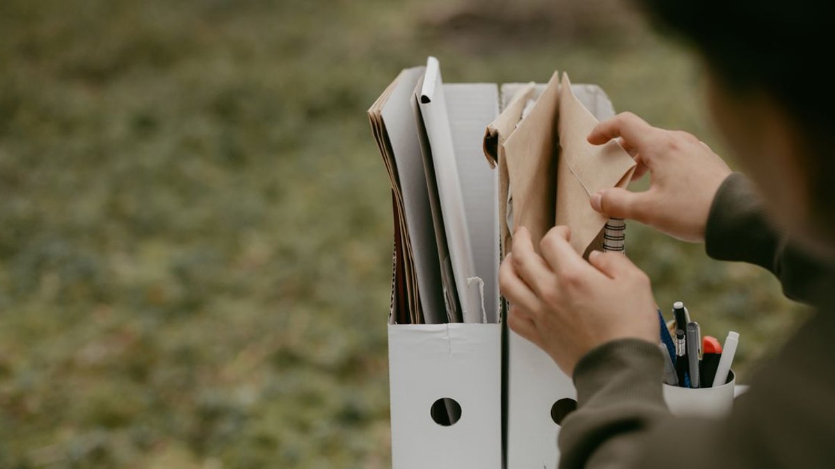 자금 항목은 어떻게 나눠서 볼 수 있을까? — 통증클리닉 개원 자금 계획을 실제로 세울 때는 아래처럼 여섯 항목으로 나눠 각각의 배분 시점과 우선순위를 따로 정하는 방식을 권… · 사진: Person sorting documents in folders outdoors, hands visible, neutral tone.