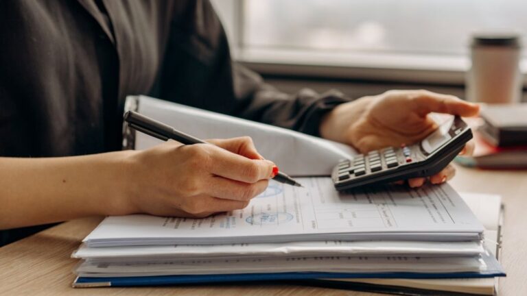 통증클리닉 개원 자금 계획 글 대표이미지 · 사진: Close-up of person using a calculator with financial documents in an office.